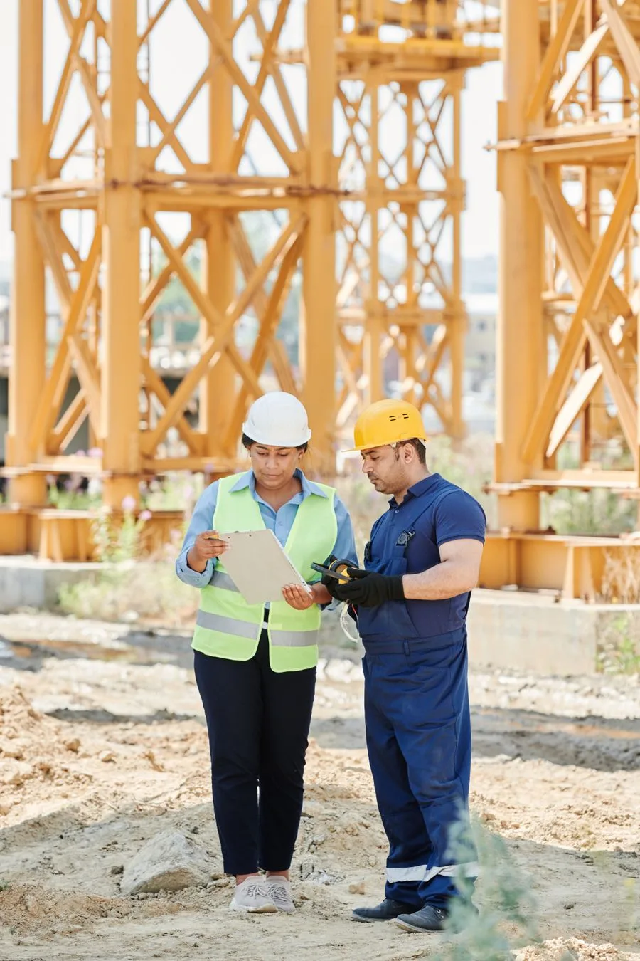 Profesionales de construcción revisando planos en una obra